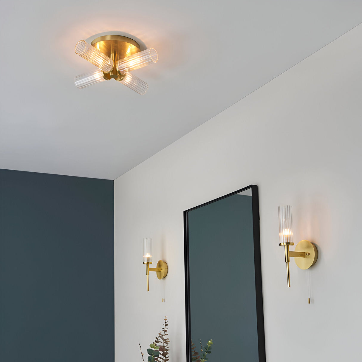 Endon Wren 4 light semi-flush bathroom ceiling light in brass with ribbed glass shades, shown lit on a white ceiling above matching brass wall lights.