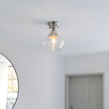 Endon Kedleston semi-flush ceiling light in nickel with clear glass shade, mounted on a white hallway ceiling near a round mirror and panelled door.