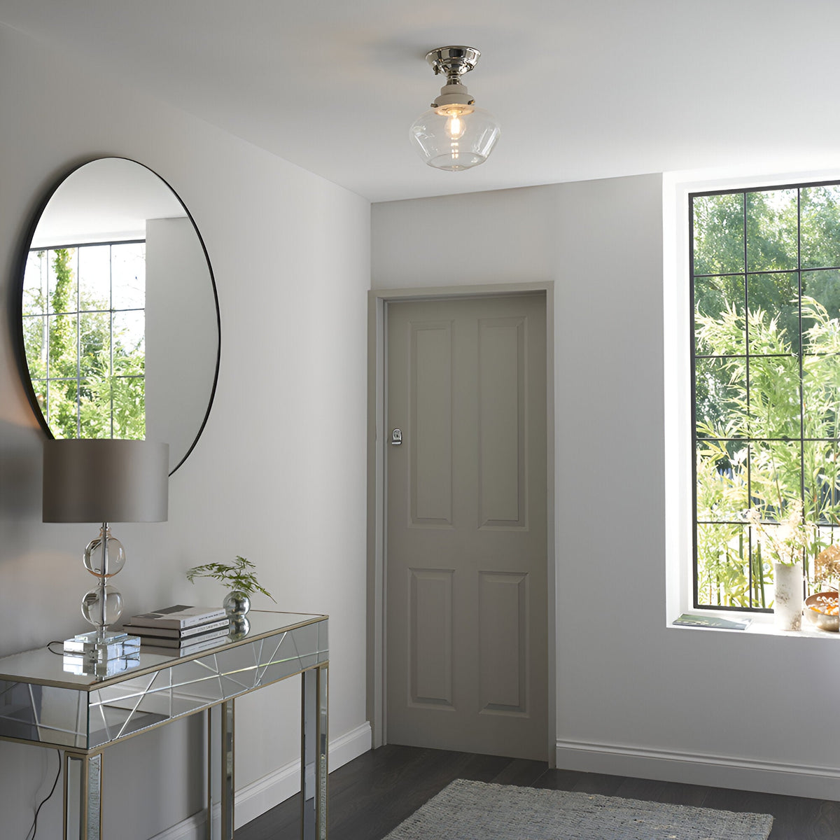 Endon Kedleston semi-flush ceiling light in nickel with clear glass shade, fitted in a bright hallway with round mirror, mirrored console and panelled door.