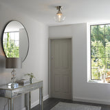 Endon Kedleston semi-flush ceiling light in nickel with clear glass shade, fitted in a bright hallway with round mirror, mirrored console and panelled door.