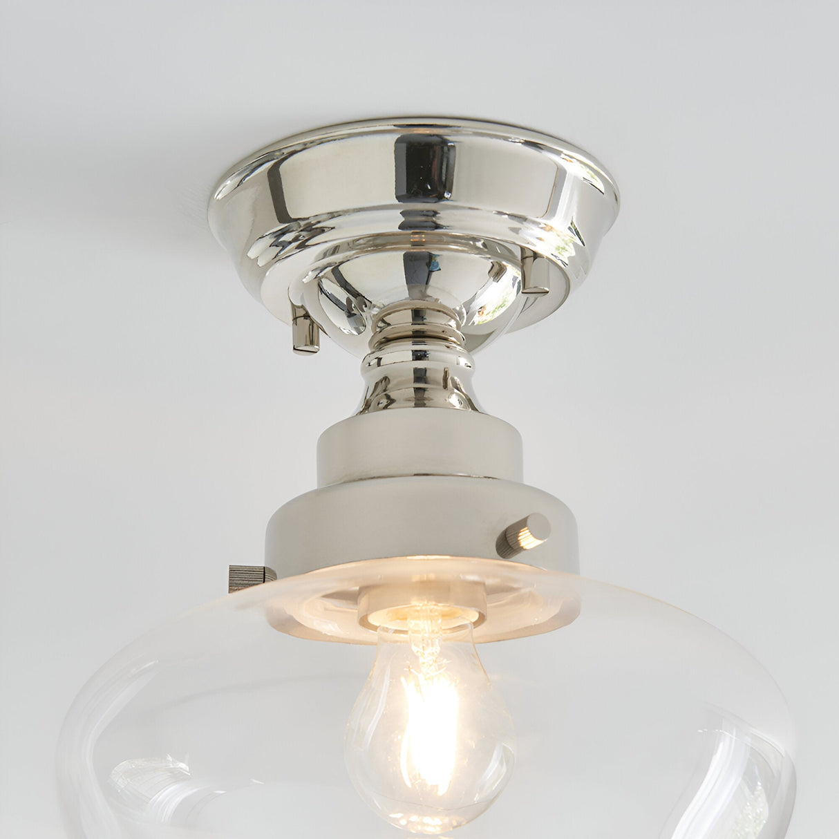 Endon Kedleston semi-flush ceiling light in nickel with a clear glass shade and exposed E27 bulb, shown close-up against a white ceiling.