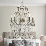 Endon Aldwood 5 light pendant in aged silver with scrolled metal frame and cascading faceted crystal drops, shown above a bed in a neutral bedroom.