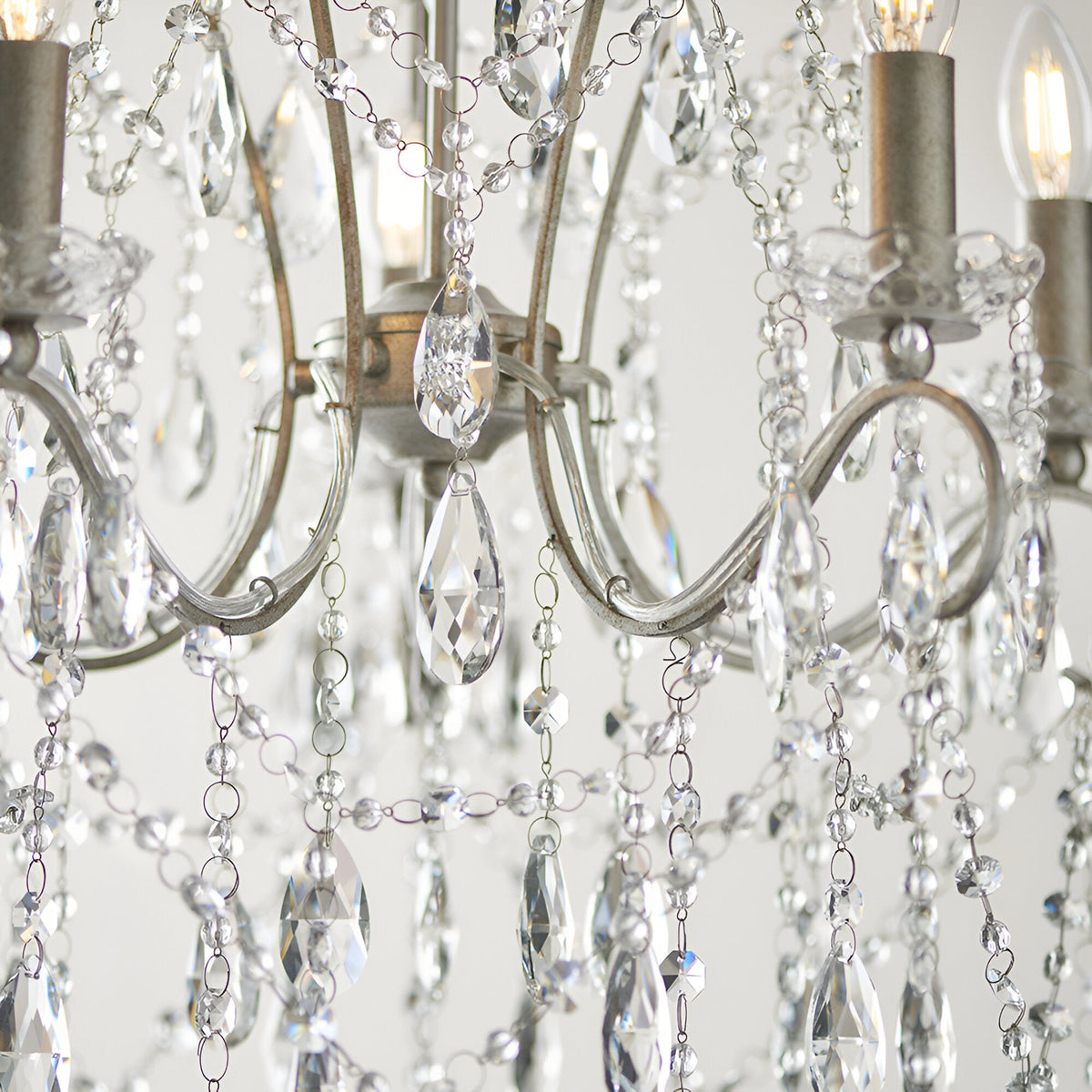 Close-up of the Endon Aldwood 5 light pendant showing aged silver scrolled arms, candle-style holders and faceted cut crystal droplets with beaded strands.