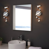 Endon Aldleigh LED wall lights in chrome with twisting spiral form, mounted either side of a rectangular bathroom mirror above a white basin.