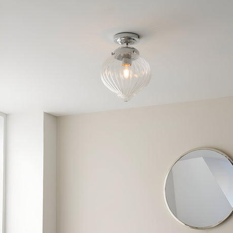Endon Thornton flush bathroom ceiling light in chrome with a ribbed clear glass teardrop shade, installed on a white ceiling above a round mirror.