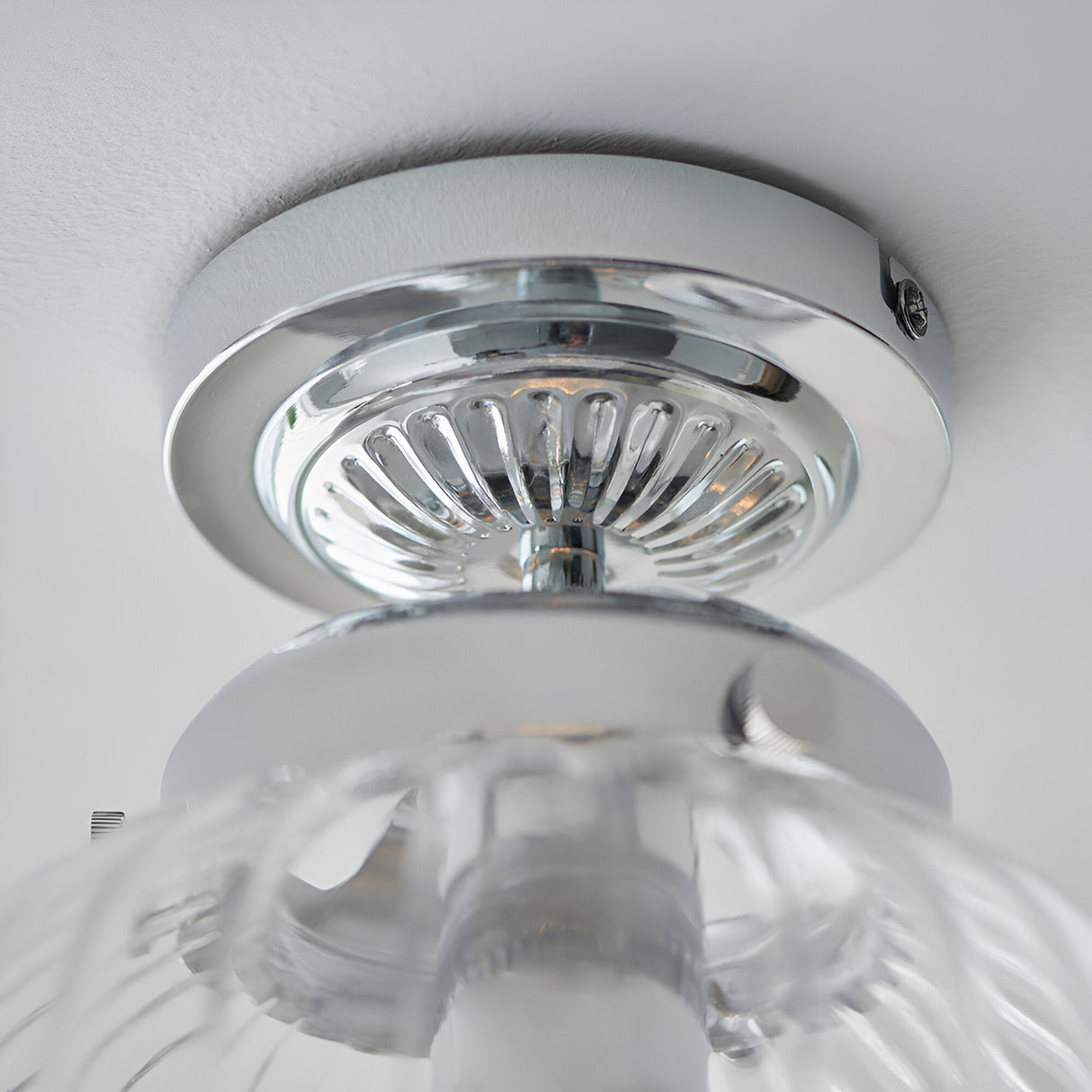 Close-up of Endon Thornton flush bathroom ceiling light showing polished chrome mount and ribbed glass diffuser fitted to a white ceiling.