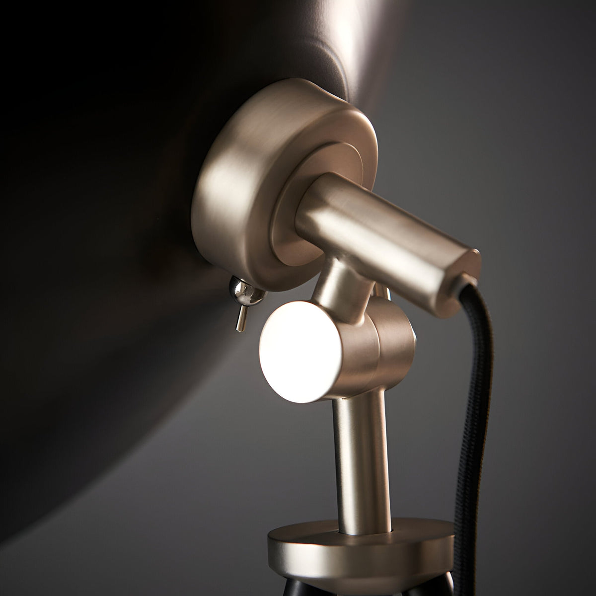 Close-up of the Endon Bramshaw floor lamp head in matt nickel, showing the adjustable tilt joint, toggle switch, and black fabric cable.