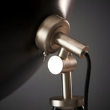 Close-up of the Endon Bramshaw floor lamp head in matt nickel, showing the adjustable tilt joint, toggle switch, and black fabric cable.