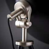 Close-up of the Endon Bramshaw floor lamp's adjustable head, showing brushed nickel tilt joint, toggle switch and black fabric cable on a black stem.
