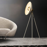Endon Bramshaw Floor Lamp in white with brushed brass details, tripod stance and tilted dish shade, shown beside a cream sofa in a living room.