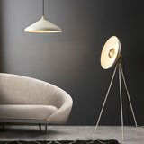 Endon Bramshaw floor lamp in white with brushed brass details, angled disc shade on a tripod stand, beside a cream curved sofa and pendant light.