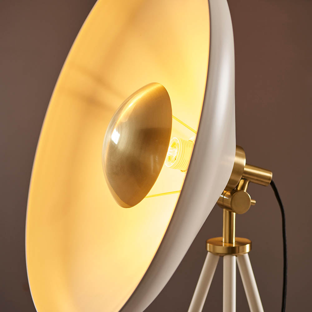 Close-up of the Endon Bramshaw Floor Lamp in white, showing the tilted domed shade, brushed brass bulb reflector and tripod joint against a dark background.