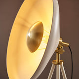 Close-up of the Endon Bramshaw Floor Lamp in white, showing the tilted domed shade, brushed brass bulb reflector and tripod joint against a dark background.