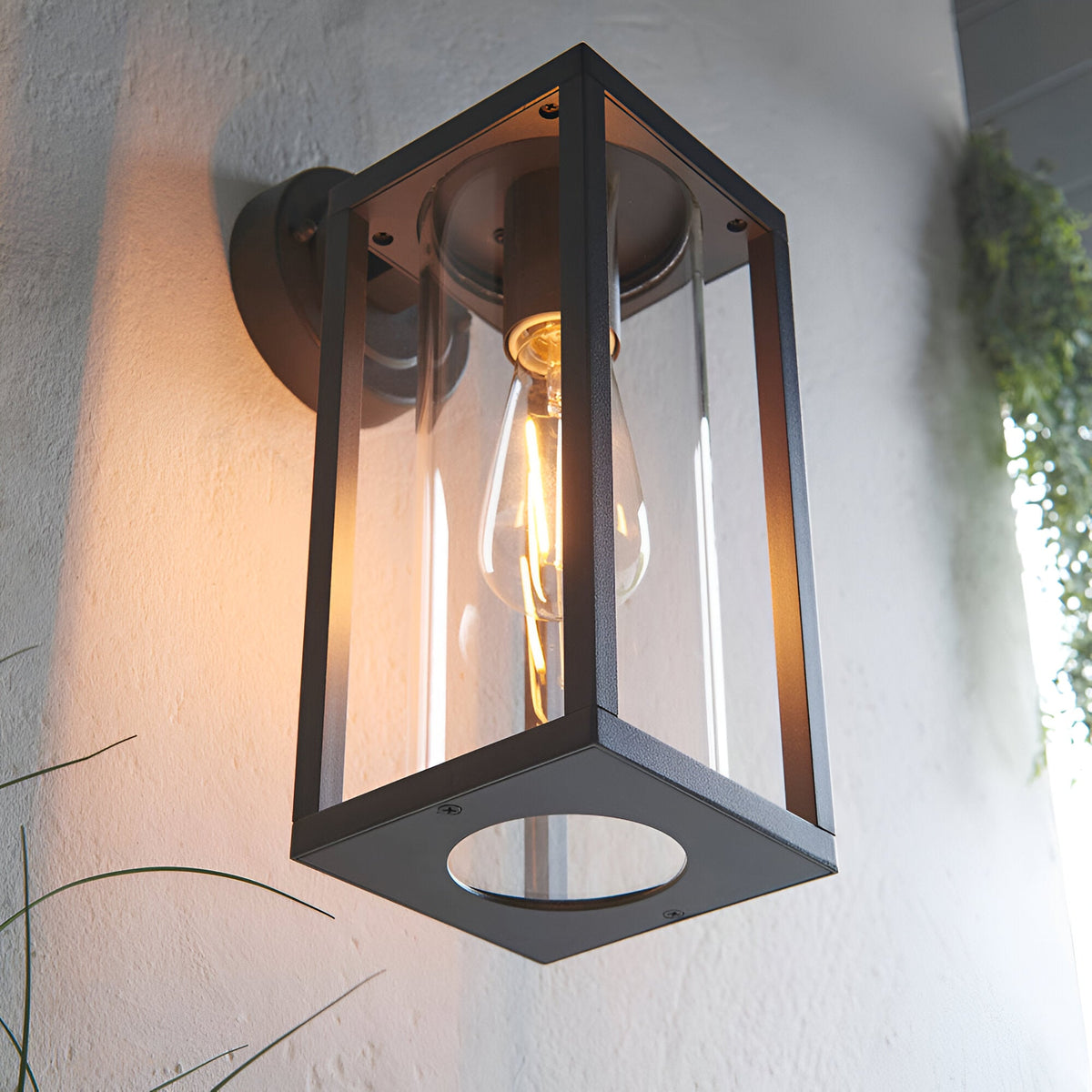 Endon Bramwood outdoor wall light in textured black with clear glass panels and an exposed filament E27 bulb, mounted on a white exterior wall.