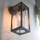 Endon Bramwood outdoor wall light in textured black with clear glass panels and an exposed filament E27 bulb, mounted on a white exterior wall.