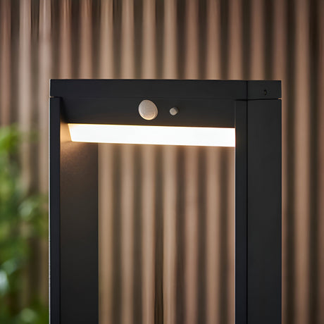 Endon Blythe LED solar post light in black aluminium with warm white diffuser and PIR sensor, shown lit beside a fluted timber outdoor screen.
