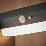 Close-up of the Endon Blythe LED solar bollard light showing the PIR motion sensor and on/off switch above the illuminated white diffuser on a black body.