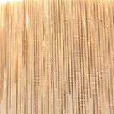 Close-up of the Endon Caststead Linear Pendant showing cascading fine silver chains in a polished chrome finish catching warm light.