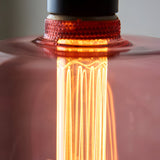 Close-up of the 2.8W E27 LED filament bulb showing pink tinted glass, visible warm white filaments, and a textured amber-red screw base.