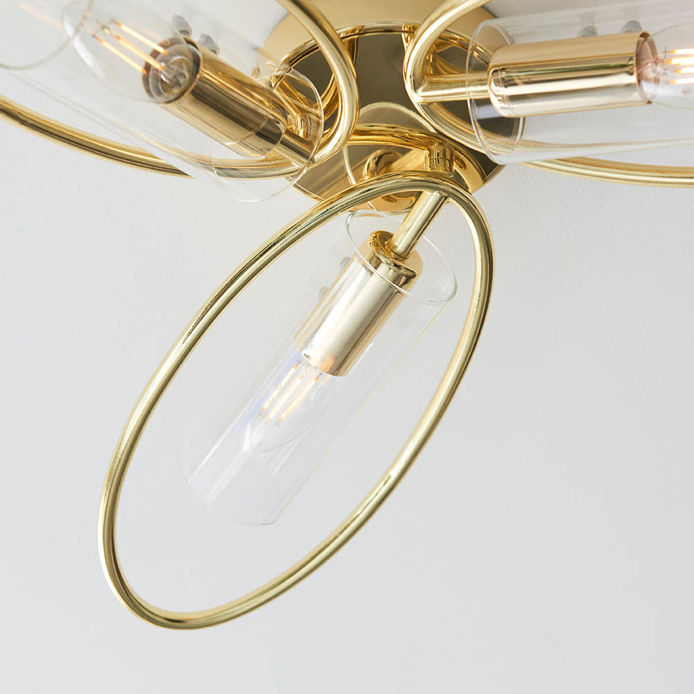 Close-up of Endon Hartley 3 light semi-flush ceiling light in brass, showing an oval arm with a clear glass cylinder shade and E14 lamp.