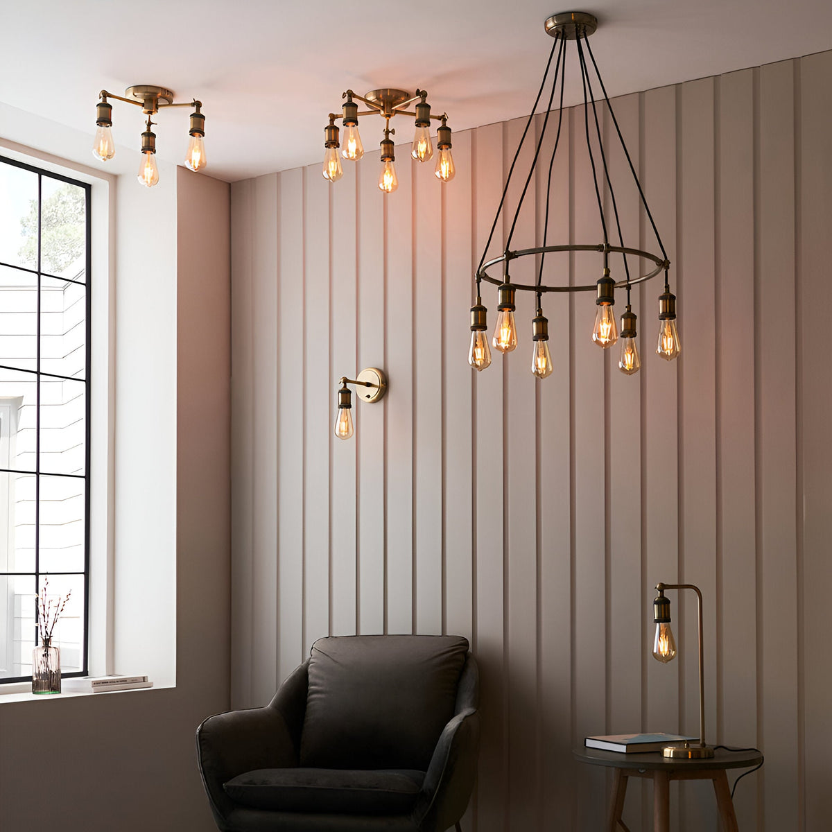 Endon Brackley brass semi-flush ceiling lights with exposed Edison bulbs shown alongside a matching wall light and table lamp in a panelled living room.