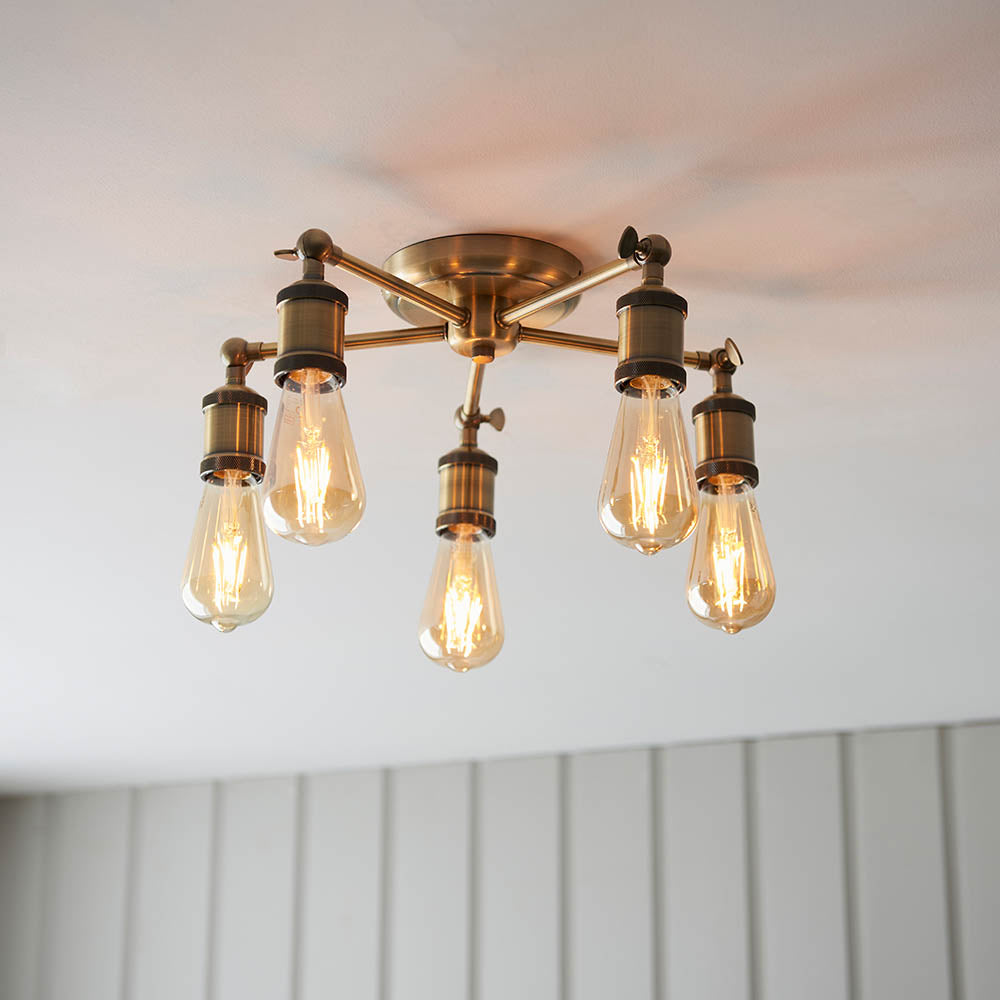 Brackley 5 Light Semi-Flush Ceiling Light in brass, five splayed arms with exposed E27 bulbs, mounted close to a white ceiling.