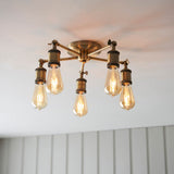 Brackley 5 Light Semi-Flush Ceiling Light in brass, five splayed arms with exposed E27 bulbs, mounted close to a white ceiling.