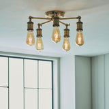 Brackley 5 Light Semi-Flush Ceiling Light in brass with five splayed arms and exposed E27 bulbs, shown fitted to a room ceiling near a window.