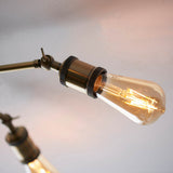 Close-up of the Brackley 5 Light Semi-Flush Ceiling Light in brass, showing an adjustable arm with knurled detailing holding an exposed filament E27 bulb.
