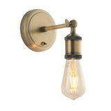 Brackley Wall Light in antique brass with an adjustable industrial-style arm, exposed E27 bulb holder, and round wall plate, shown on a plain white background.