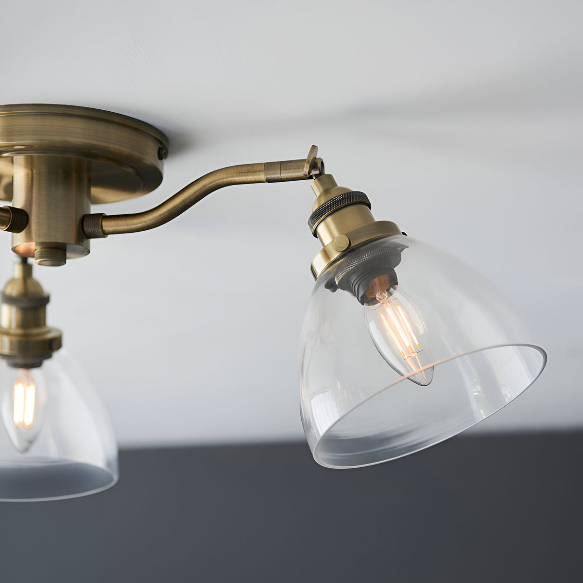 Wentworth 3 Light Semi-Flush Ceiling Light in antique brass with adjustable arms, clear glass shades, and visible filament bulbs.