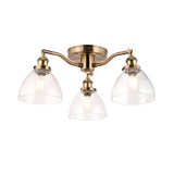 Wentworth 3-light semi-flush ceiling light in antique brass with clear glass dome shades on three arms, plain white background.