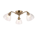 Wentworth 3-light semi-flush ceiling light in antique brass, three angled arms with clear glass dome shades, shown on a plain white background.