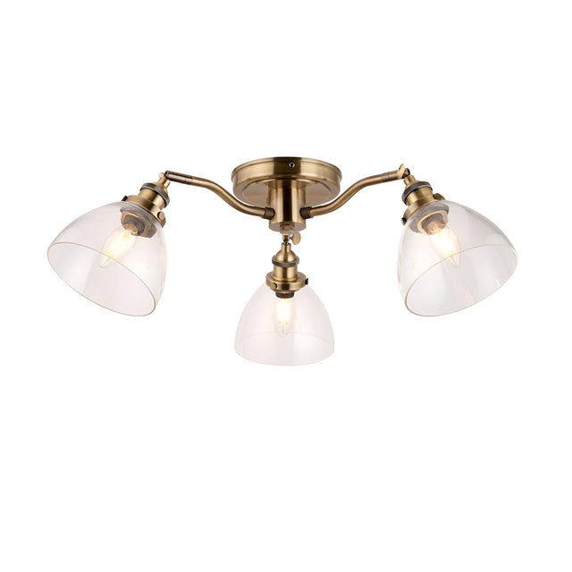 Wentworth 3-light semi-flush ceiling light in antique brass, three angled arms with clear glass dome shades, shown on a plain white background.