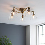 Endon Wentworth 5 light semi-flush ceiling light in antique brass with clear glass dome shades, installed on a white ceiling in a bright room.