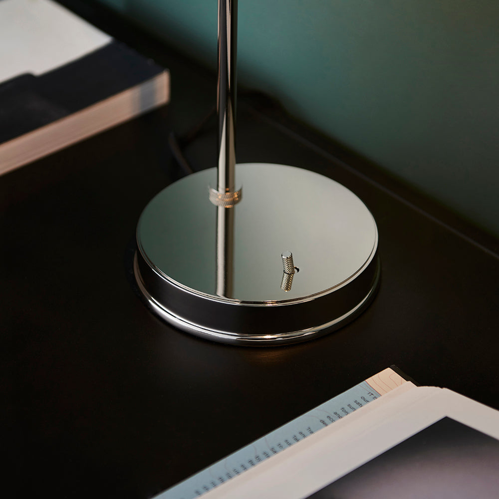 Close-up of the Endon Wentworth table lamp base in nickel, showing the round polished disc, knurled fitting and toggle switch on a dark desk.