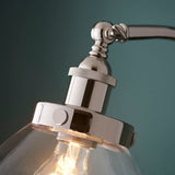 Close-up of the Endon Wentworth floor lamp's polished nickel head, showing the knurled lamp holder, adjustable knuckle, and clear glass shade with visible bulb.