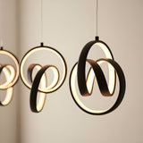 Bevwell 5 Light Linear Pendant in matt black metal, looped ring forms with integrated LED lighting, shown against a plain neutral wall.