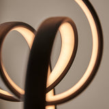 Close-up of the Bevwell 5 Light Linear Pendant in matt black metal, showing looped forms with integrated LEDs casting a warm glow.