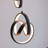 Endon Bevwell pendant light in matt black, showing looped metal rings with integrated warm LED strips against a pale grey background.