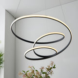 Endon Halden pendant light with three interlocking textured black rings and warm integrated LED diffusers, suspended in a modern white interior.