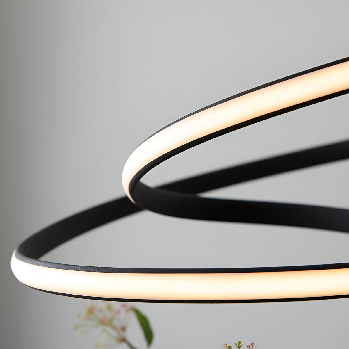 Close-up of the Endon Halden pendant light showing intertwined textured black loops with an illuminated white LED diffuser strip.