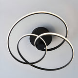 Endon Halden LED semi-flush ceiling light with three interlinked matt black rings around a circular backplate, mounted on a pale ceiling.
