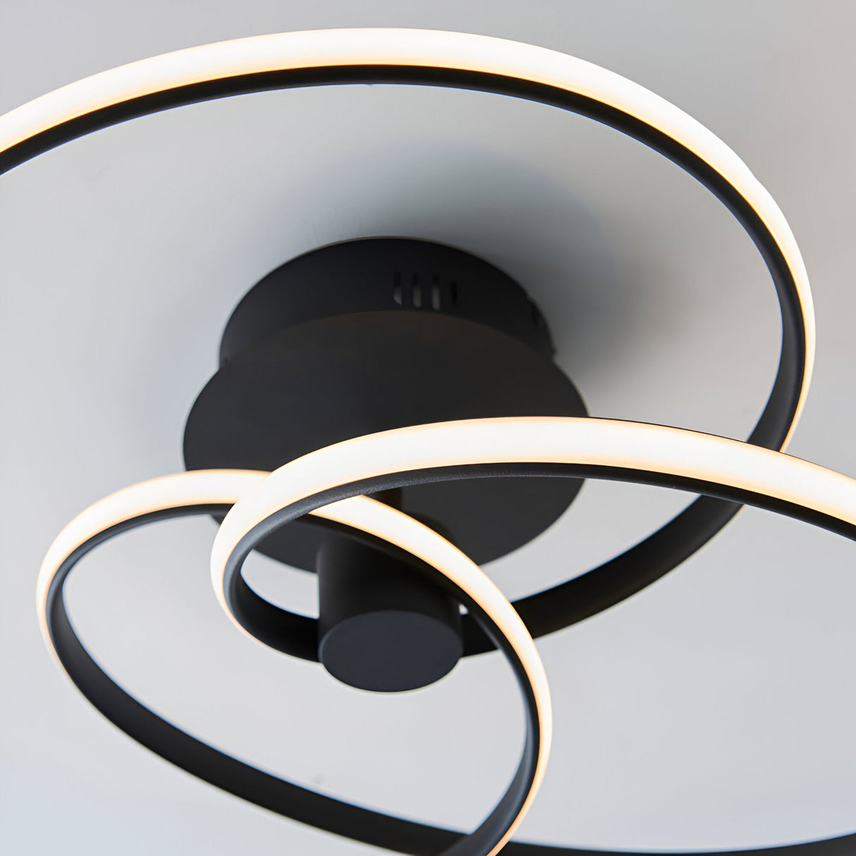 Endon Halden semi-flush ceiling light in matt black metal, shown from below with looping LED bands around a round backplate on a white ceiling.