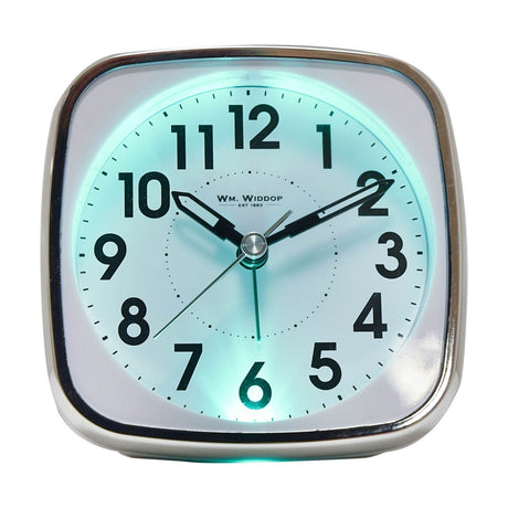 Square white plastic alarm clock with silver trim, black Arabic numerals, sweep second hand, and glowing turquoise backlight, shown on a plain background.