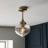 Endon Aldridge semi-flush ceiling light in antique brass with a ribbed clear glass onion-shaped shade and E27 lamp, mounted in a hallway.