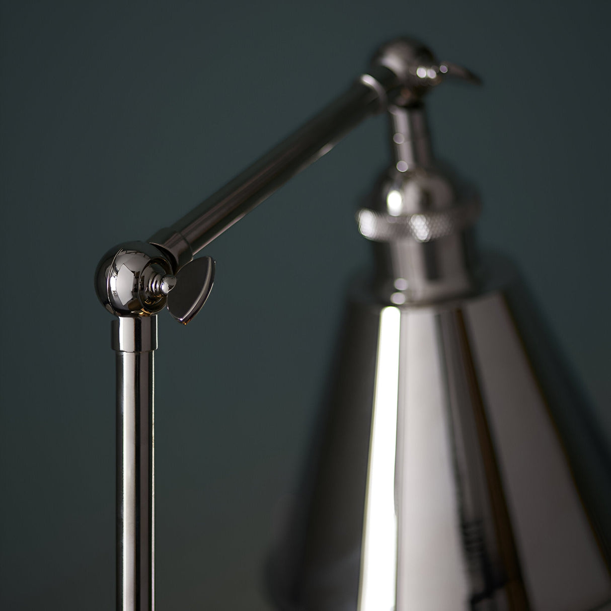 Close-up of the Endon Brackley table lamp's adjustable arm joint and conical shade in bright nickel with knurled detailing.