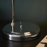 Close-up of the Endon Brackley table lamp base in bright nickel, showing the round polished plinth, knurled stem detail and toggle switch.