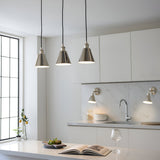 Endon Brackley 3 light linear pendant in nickel with conical shades and white inner, hung over a kitchen island with white cabinetry and marble splashback.