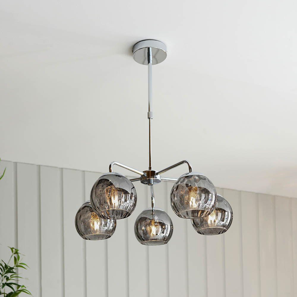 Draycott 5 Light Dimpled Glass Pendant in Chrome, five smoked mirrored globe shades on a chrome frame, hung from a ceiling rose in a bright room.